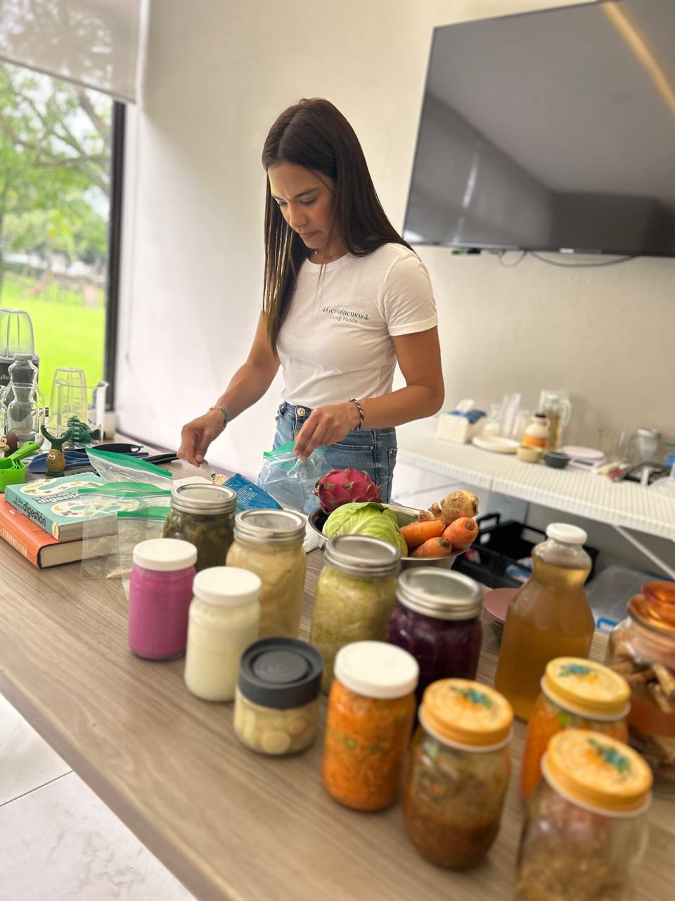 Danelia trabajando frente a una mesa con frascos de fermentos caseros